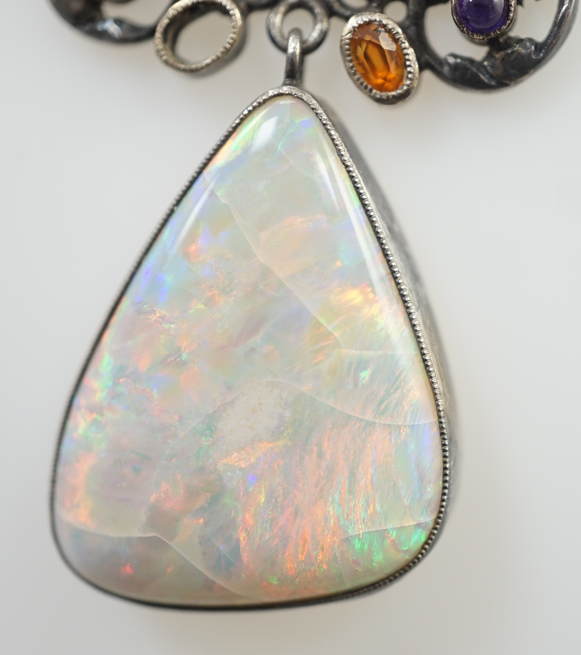 An early 20th century silver, white opal and cabochon gem cluster set drop pendant necklace, in the manner of Sibyl Dunlop